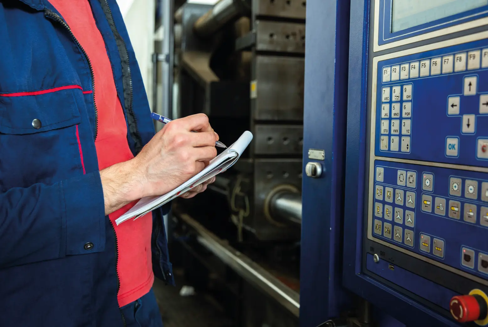 Técnico industrial registrando parámetros frente a panel de control CNC – Profan.cl